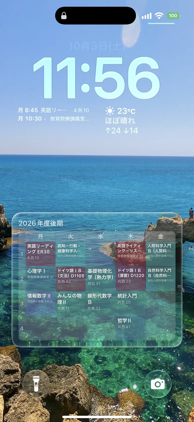 iPhoneのロック画面。海の写真の上に後期の時間割がすりガラスの板で重なり、時計の下に月曜の授業と教室が並ぶ。